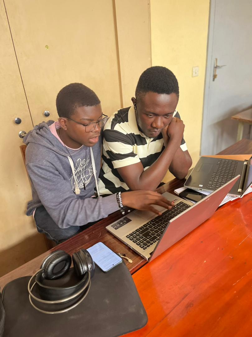 Two students focused on the same laptop during the cybersecurity challenge